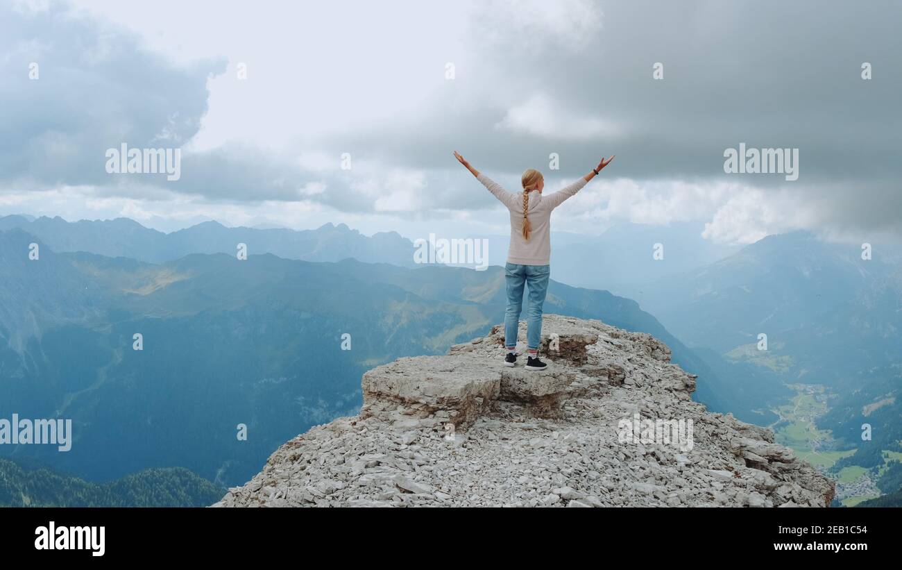 Jeune femme aux bras étirés appréciant la beauté de la nature sur le rocher de montagne. Vue fantastique sur le paysage. Banque D'Images