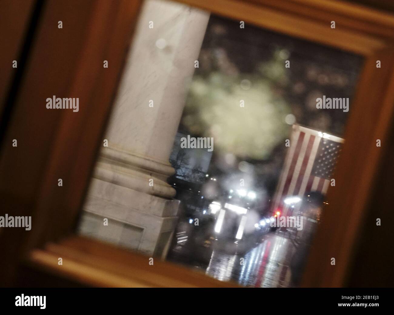 Washington, États-Unis. 11 février 2021. Le drapeau américain se reflète dans une porte lambrissée de verre qui a été brisée par des émeutiers le 6 janvier au Capitole des États-Unis à Washington, DC, le mercredi 10 février 2021. Le matin du 11 février, des travailleurs ont été vus en remplacement du verre brisé. Photo de Leigh Vogel/UPI crédit: UPI/Alay Live News Banque D'Images