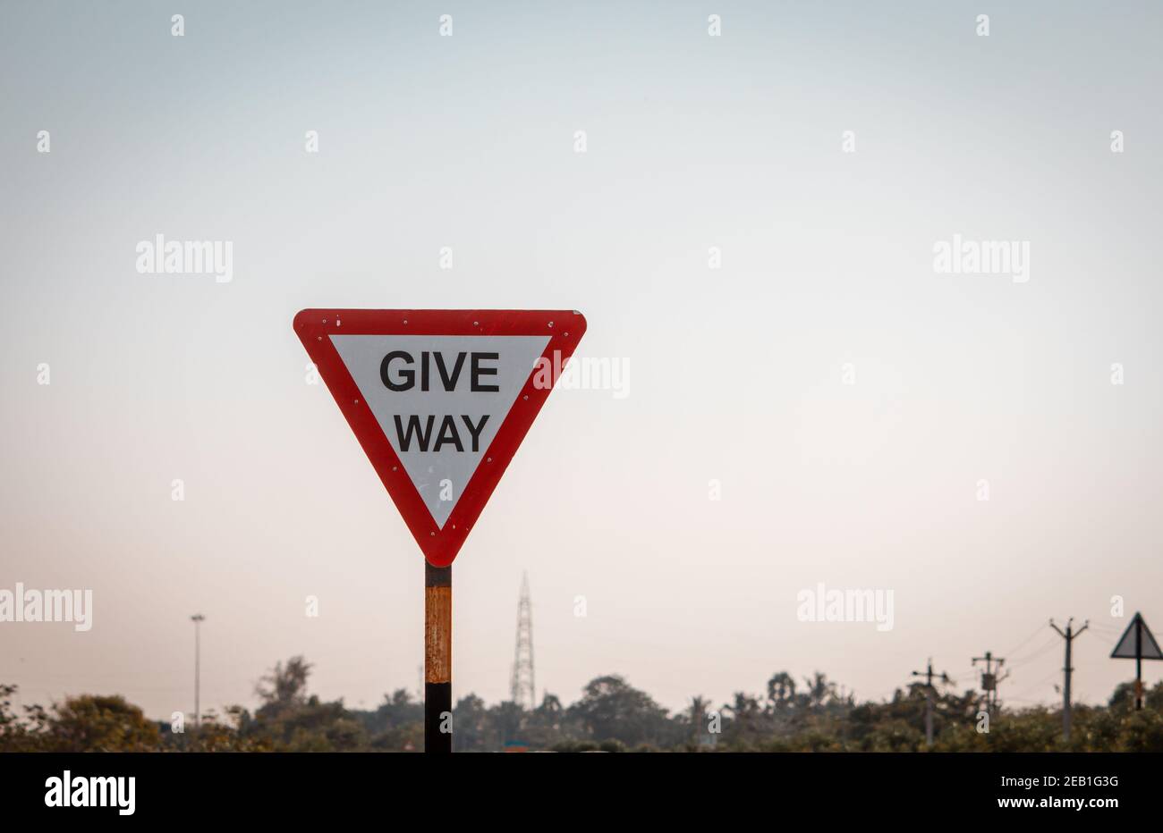 Panneau obligatoire de la route indienne indiquant de laisser la place à la circulation en cours. Panneau indiquant « céder » lors de la reprise de la route Banque D'Images Panneau obligatoire de la route indienne indiquant de laisser la place à la circulation en cours. Panneau indiquant « céder » lors de la reprise de la route Banque D'Images