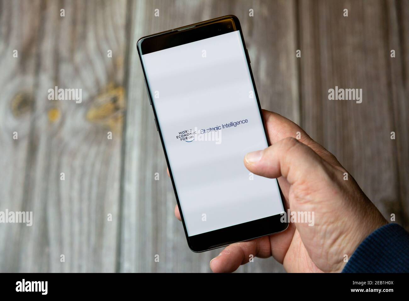 Un téléphone mobile ou mobile détenu par un Main avec l'application Forum économique mondial ouverte à l'écran Banque D'Images
