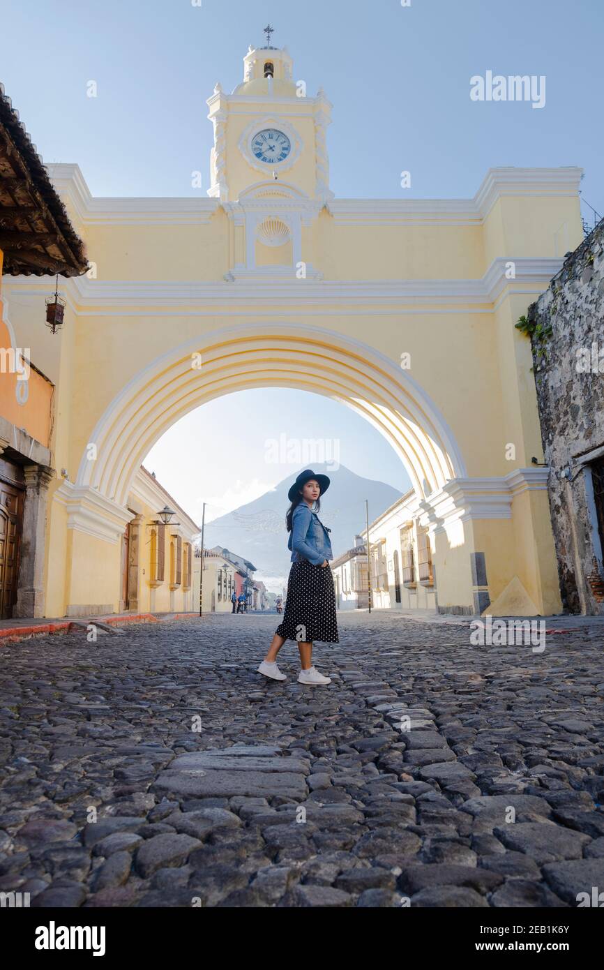 Jeune femme hispanique debout sous l'arche de Santa Catalina À Antigua Guatemala - touriste sur l'importante avenue coloniale Guatemala avec le Banque D'Images