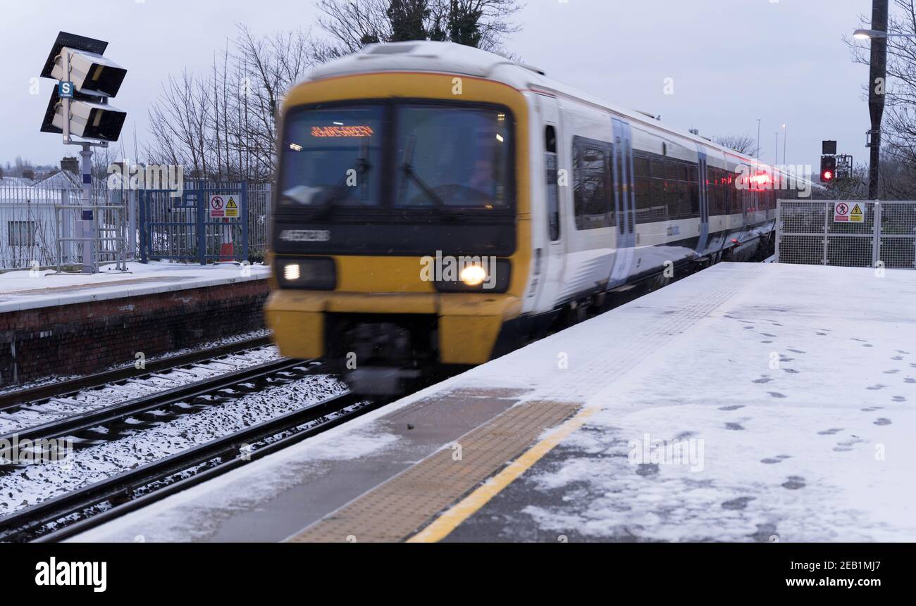 Le train du sud-est s'est déplacé vers la plate-forme de la gare recouverte de neige de la tempête Darcy, Kent Banque D'Images