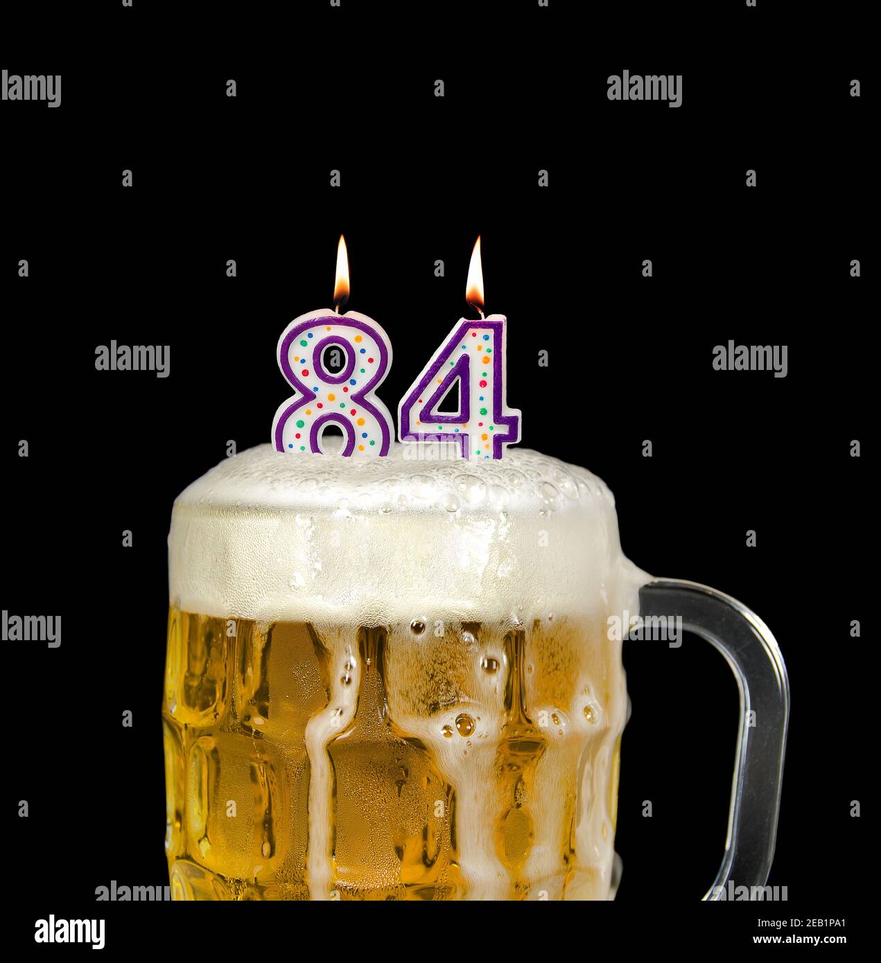 bougie numéro 84 dans une tasse à bière pour la fête d'anniversaire isolée sur le noir Banque D'Images