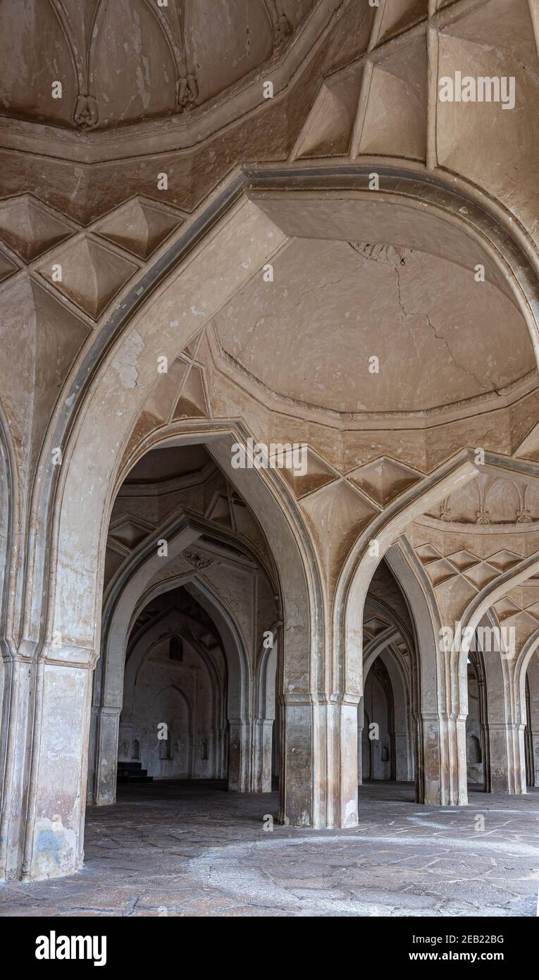 Vijayapura, Karnataka, Inde - 8 novembre 2013 : portrait de la salle voûtée beige brun et des piliers de la mosquée Ibrahim Rauza. Banque D'Images