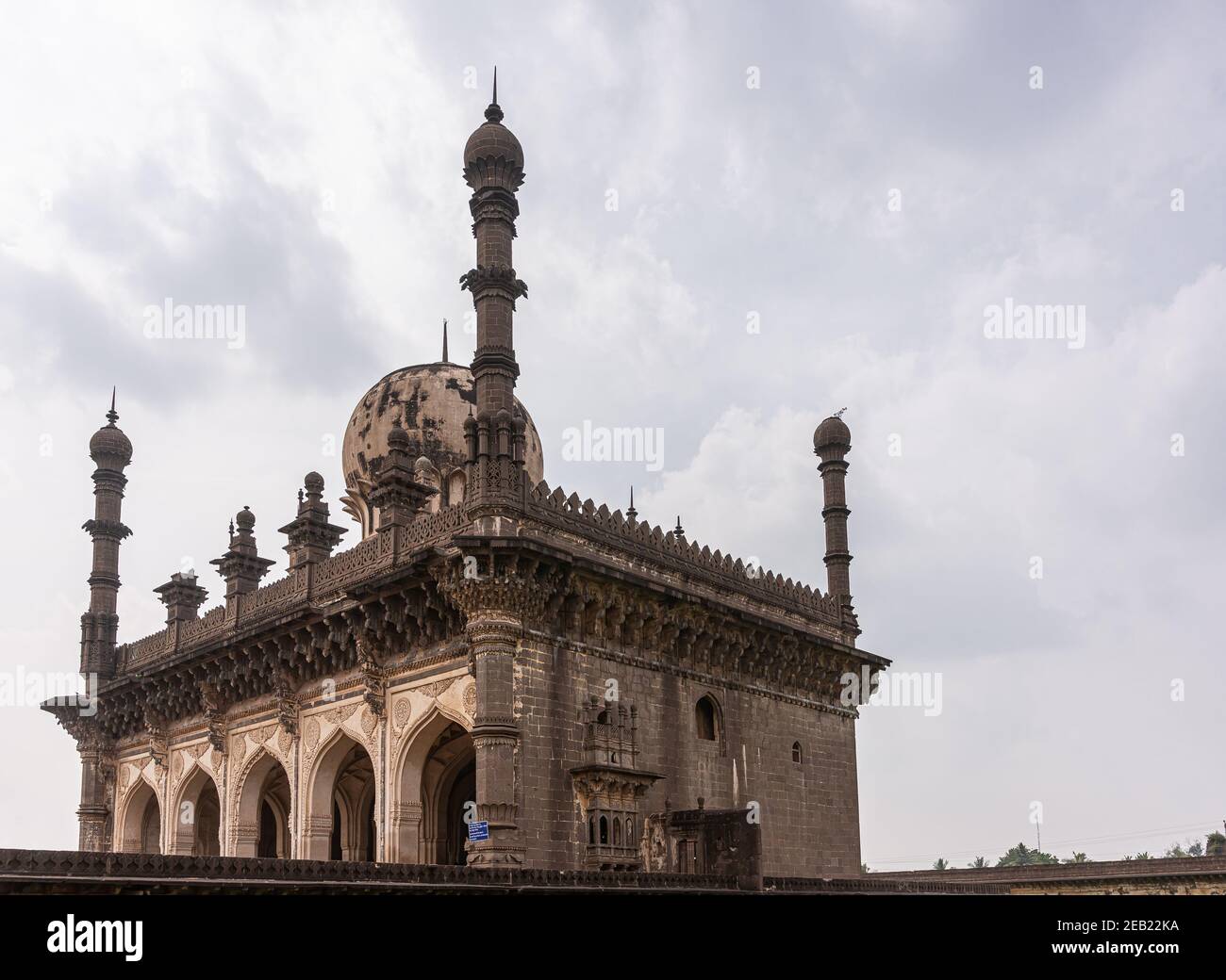Vijayapura, Karnataka, Inde - 8 novembre 2013 : vue d'angle ne sur la mosquée Ibrahim Rauza en pierre brune sous couvert de nuages gris. Banque D'Images