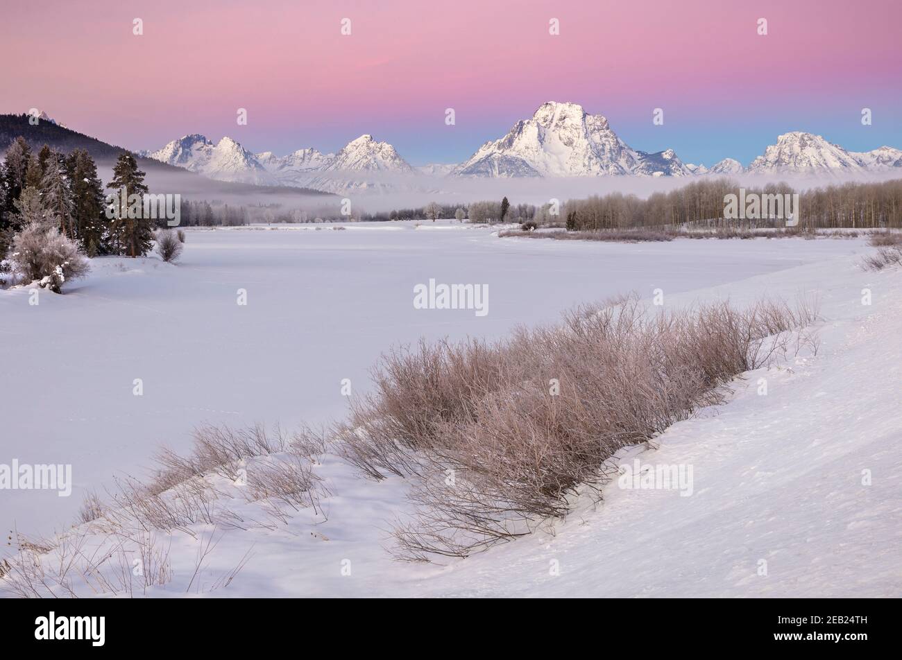 Parc national de Grand Teton, Wyoming : Mount Moran et Teton Range à l'aube avec un brouillard de basse altitude provenant de l'Oxbow de la rivière Snake en hiver Banque D'Images