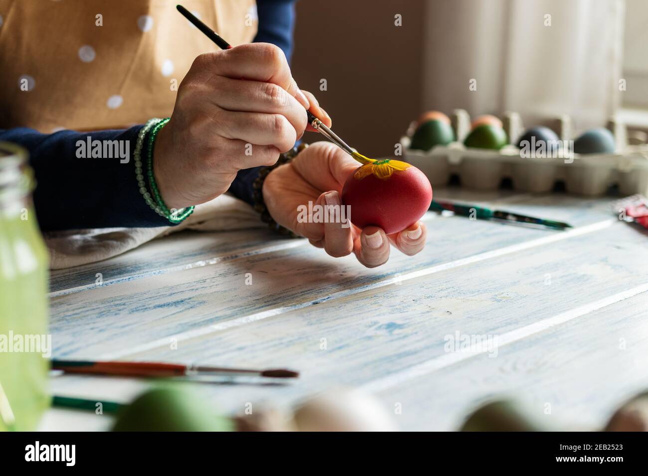 Femme peignant des oeufs de pâques. Décoration maison pour des vacances religieuses traditionnelles. Art et artisanat Banque D'Images