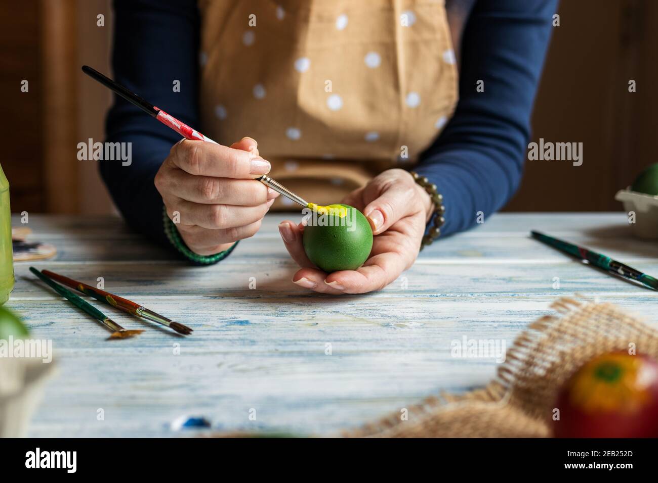 Femme peignant l'œuf et se préparant à la fête de Pâques. Décoration maison. Art et artisanat Banque D'Images