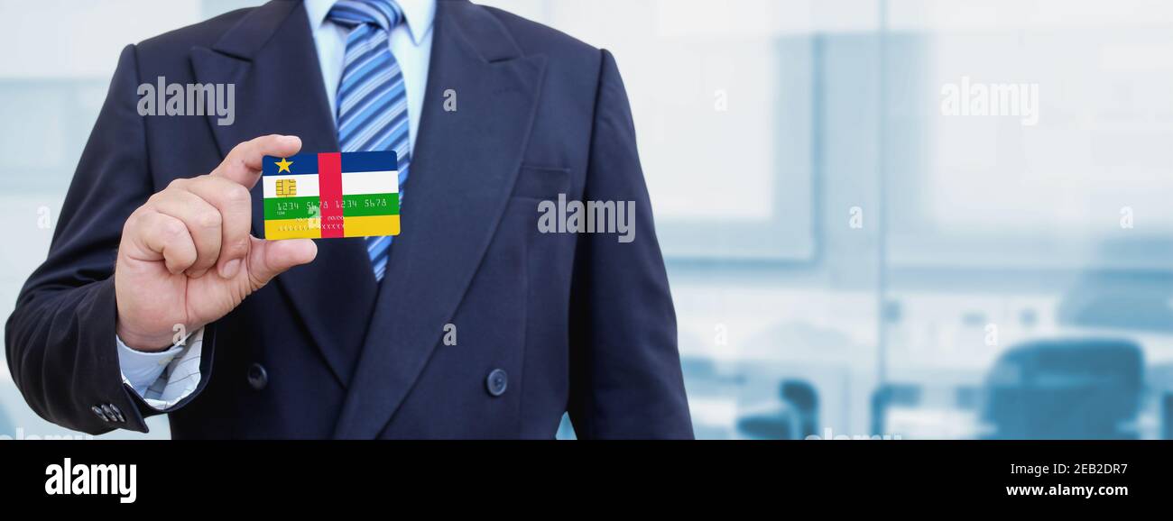Image rognée d'un homme d'affaires muni d'une carte de crédit en plastique avec drapeau imprimé de la République centrafricaine. Arrière-plan flou. Banque D'Images