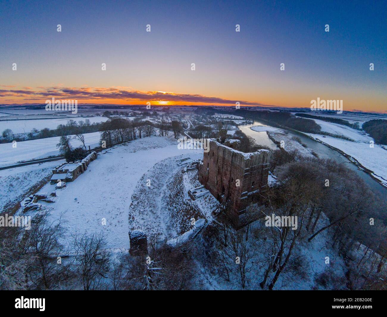 Vue aérienne du château de Norham, qui se dresse au-dessus de la rivière Tweed, un sujet favori de Turner qui lui a attribué une grande partie de sa renommée. Banque D'Images