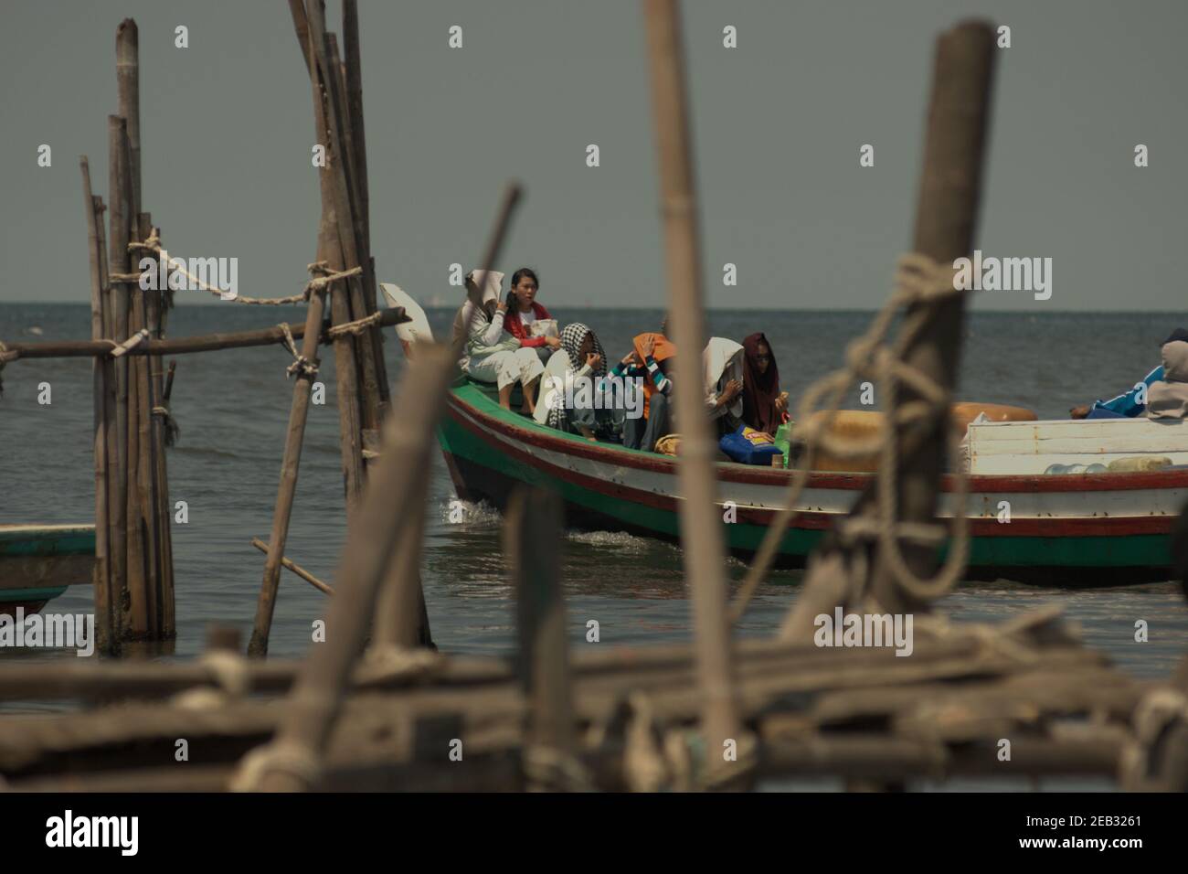 Touristes nationaux à bord d'un bateau de pêche au départ du village de Kamal Muara, dans la zone côtière de Jakarta, en Indonésie ; en direction des îles de Seribu, dans la baie de Jakarta, pour les loisirs. Banque D'Images