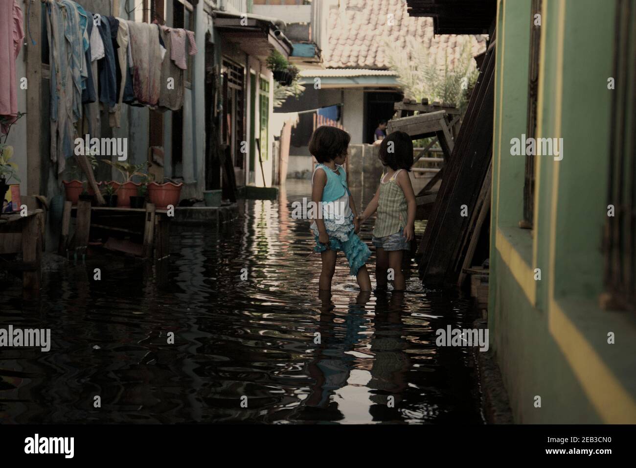 Enfants dans une ruelle résidentielle souffrant d'inondations à Kamal Muara, un village côtier de Jakarta, en Indonésie. Banque D'Images