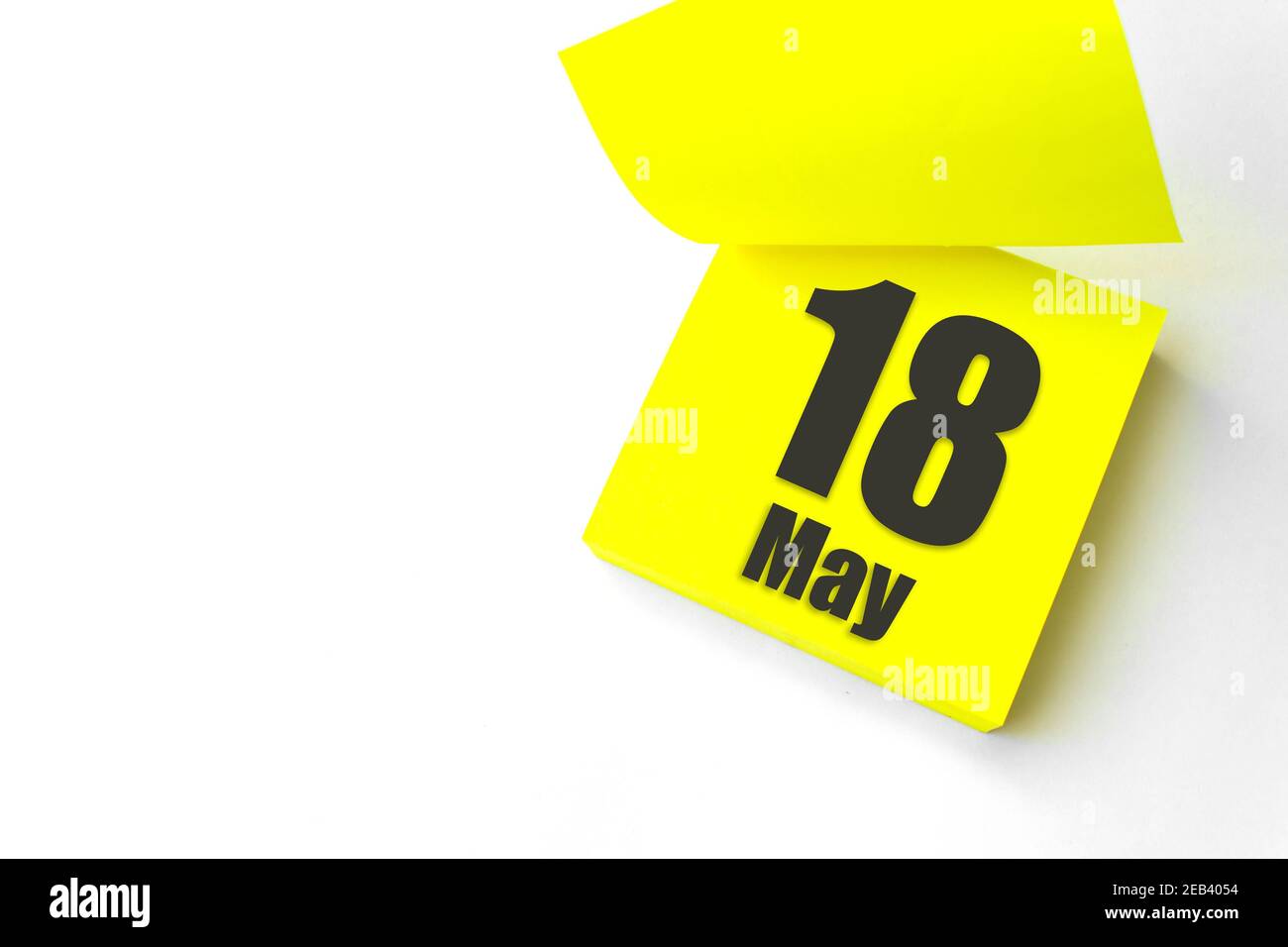 18 mai. Jour 18 du mois, date du calendrier. Gros plan papier vierge autocollant de rappel jaune sur fond blanc. Concept du mois de printemps, du jour de l'année Banque D'Images
