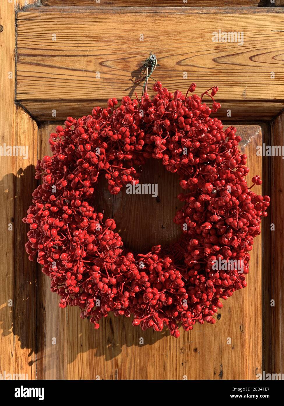 Gros plan d'une couronne de houx rouge sur une porte en bois à Charleston, en Caroline du Sud Banque D'Images