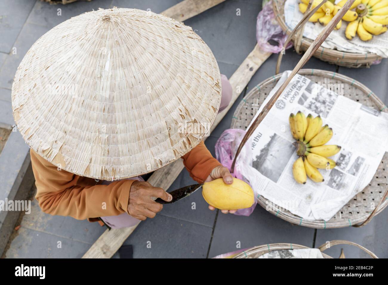 Une femme qui vend des fruits dans les rues de Hoi an, dans le centre du Vietnam. Banque D'Images
