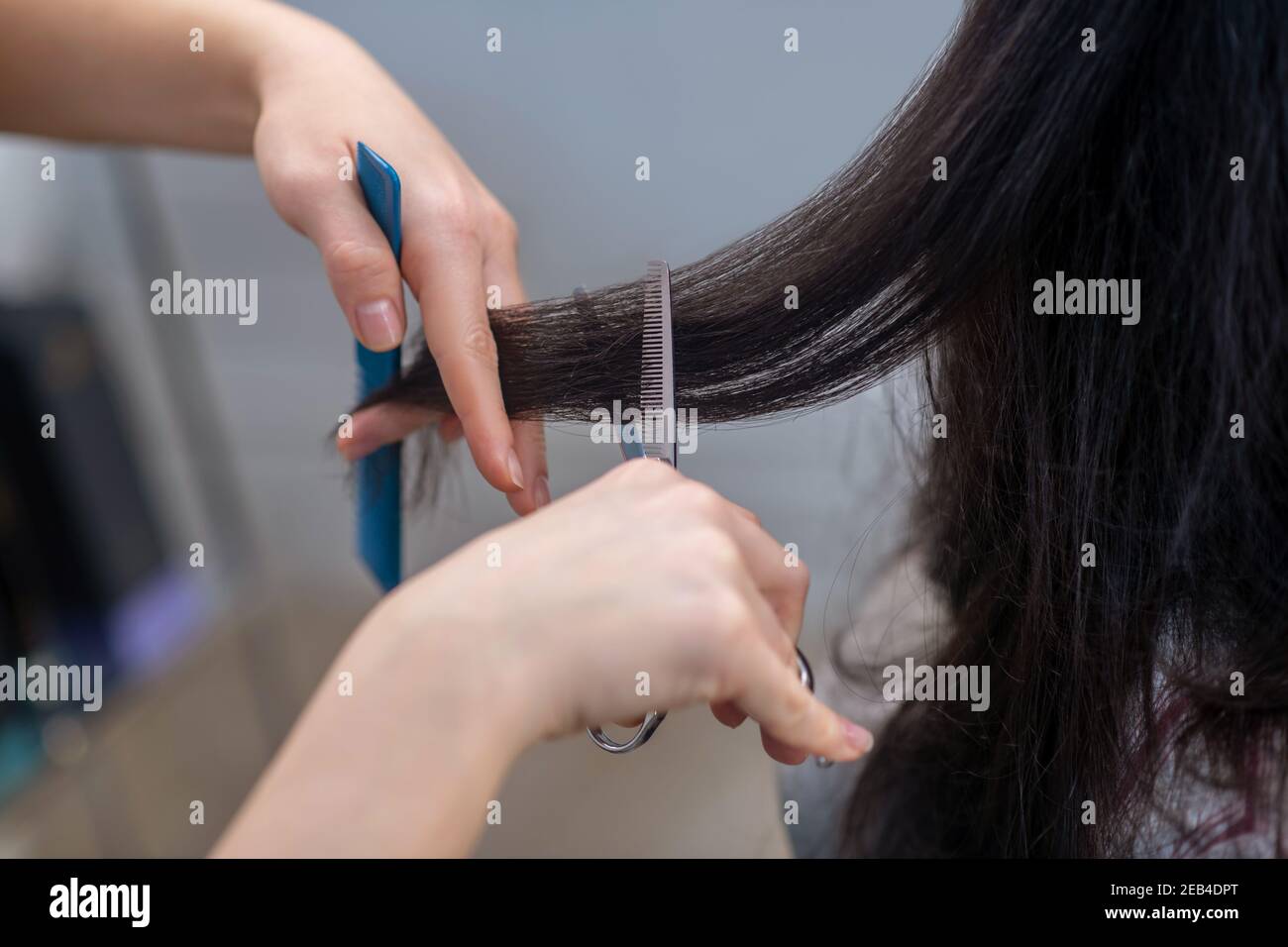 Gros plan de la peinture de la main du coiffeur pendant la coupe de cheveux processus Banque D'Images