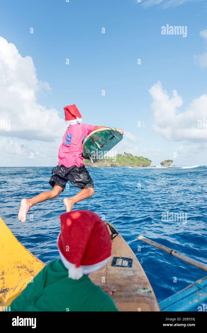 Surfeurs enfants saut dans l'océan pour le surf, Banque D'Images