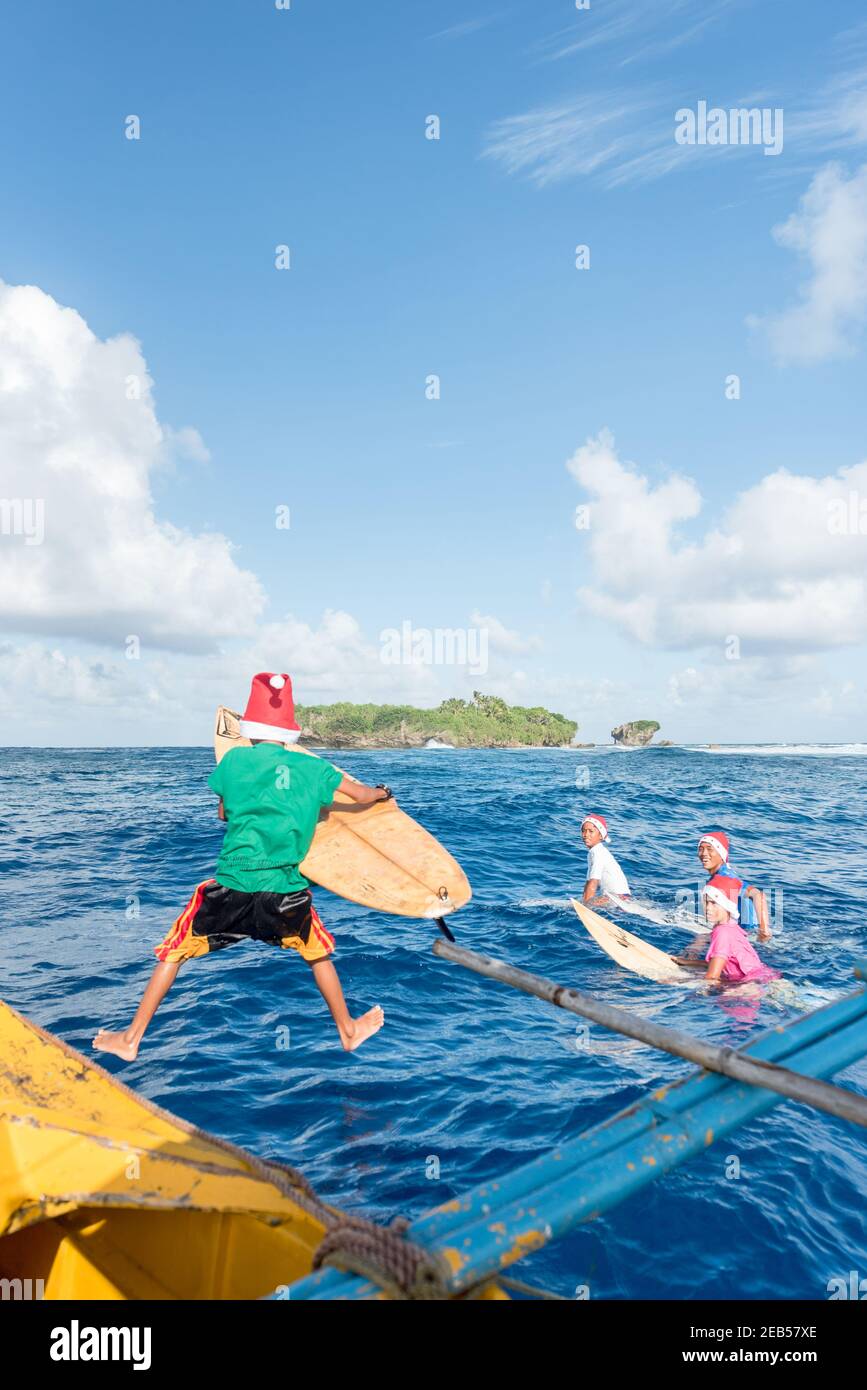 Surfeurs enfants saut dans l'océan pour le surf, Banque D'Images