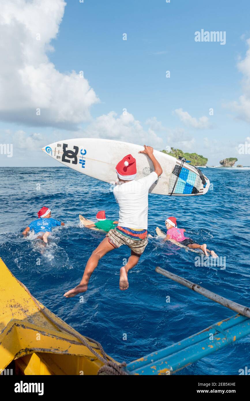 Surfeurs enfants saut dans l'océan pour le surf, Banque D'Images