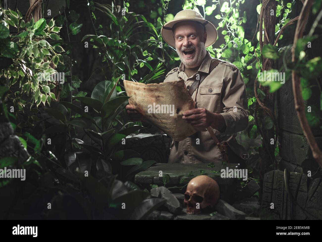 Aventurier enjoué à l'exploration de la jungle, il vérifie une carte ancienne Banque D'Images