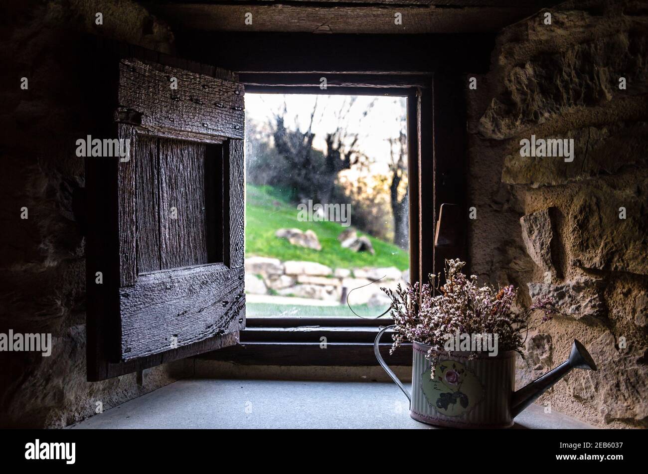 Vue intérieure de la fenêtre d'une maison rustique vers un beau jardin avec des arbres Banque D'Images