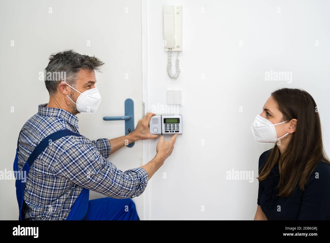 Installation du système d'alarme de sécurité par le technicien dans le masque facial Banque D'Images