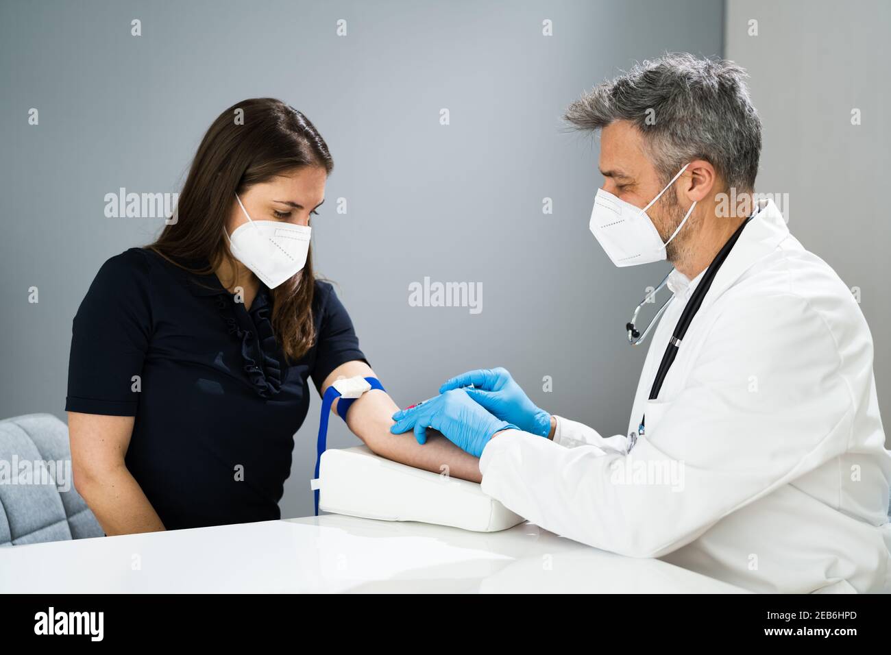 Prélèvement sanguin par le médecin en laboratoire dans le masque facial Banque D'Images