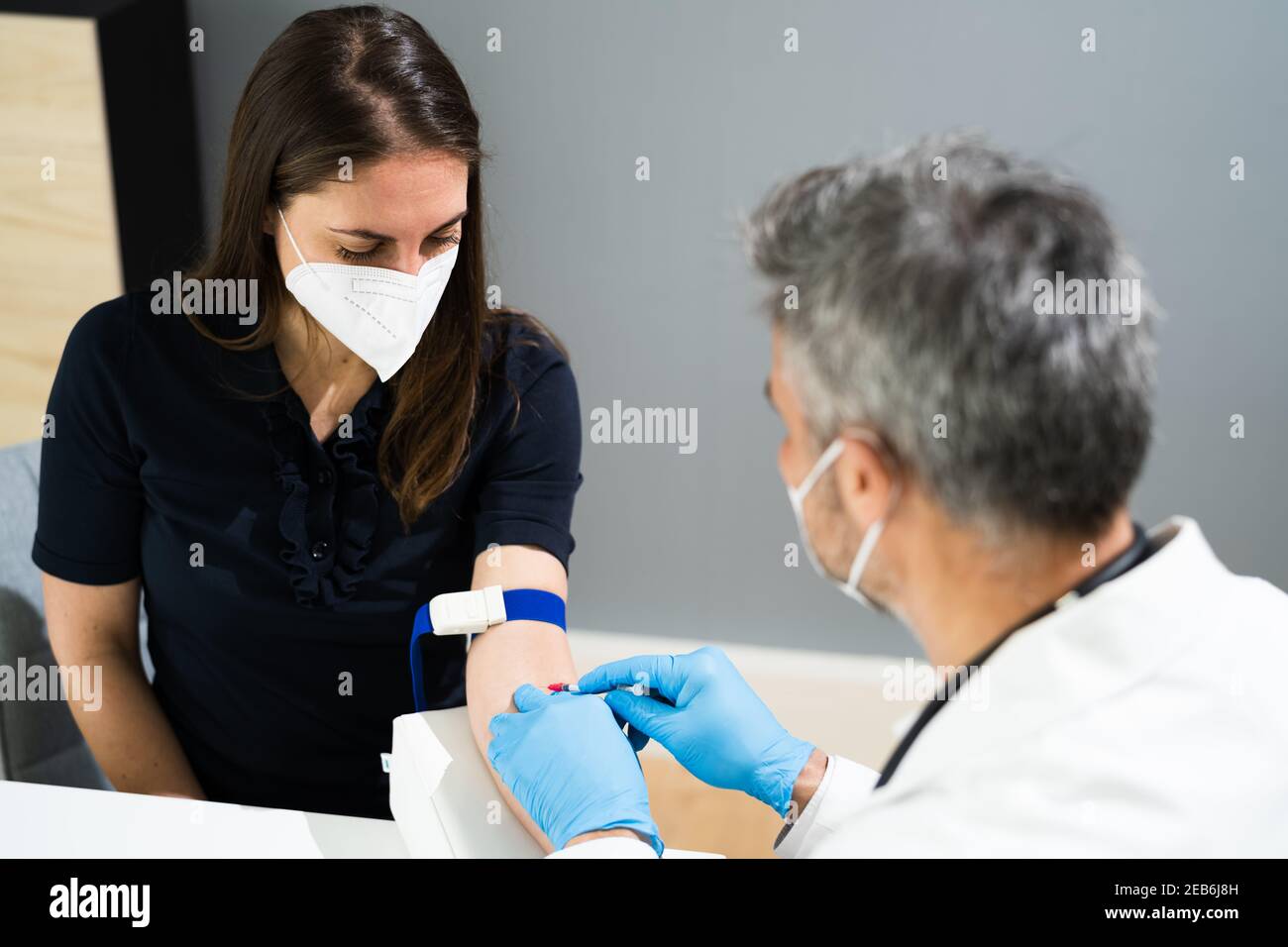 Prélèvement sanguin par le médecin en laboratoire dans le masque facial Banque D'Images