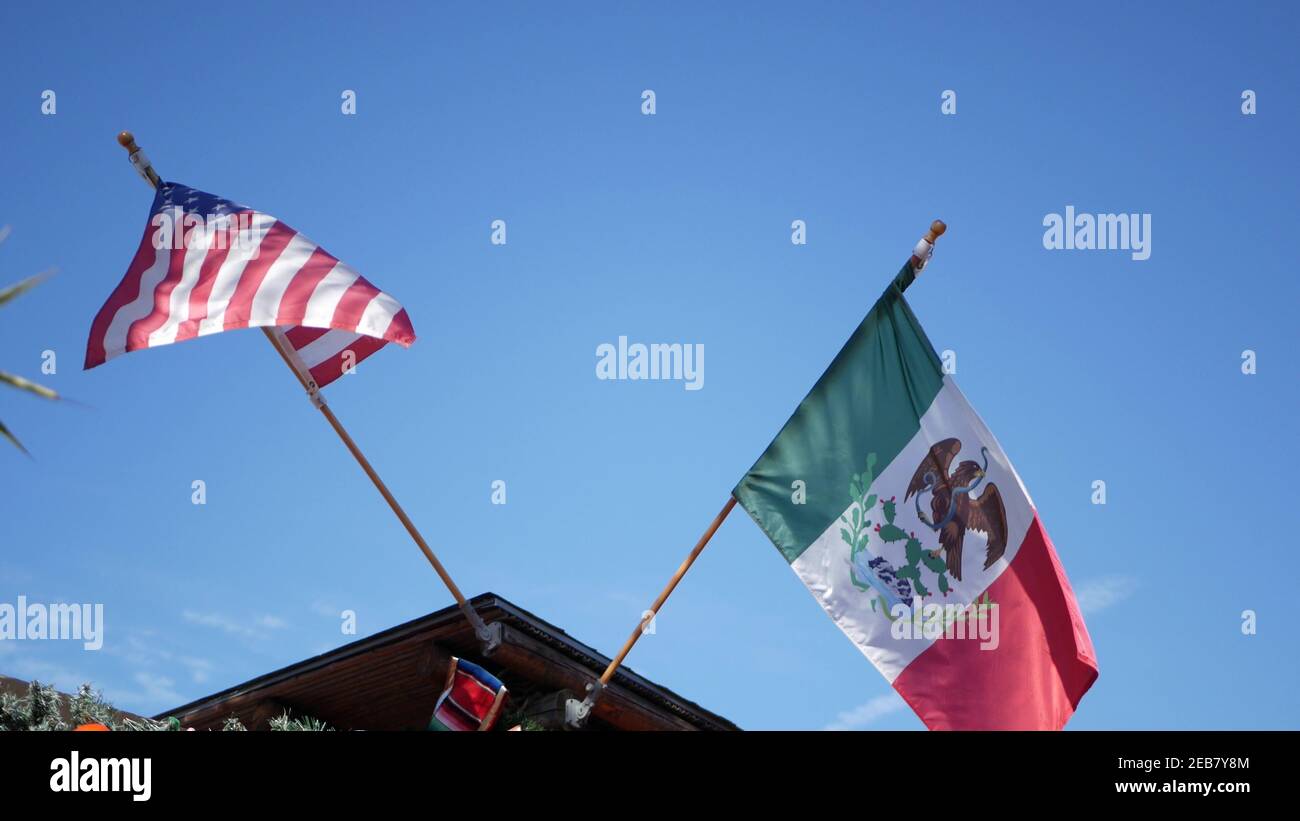 Tricolore mexicain et drapeau américain agitant sur le vent. Deux icônes nationales du Mexique et des États-Unis contre le ciel, San Diego, Californie, États-Unis. Politique s Banque D'Images