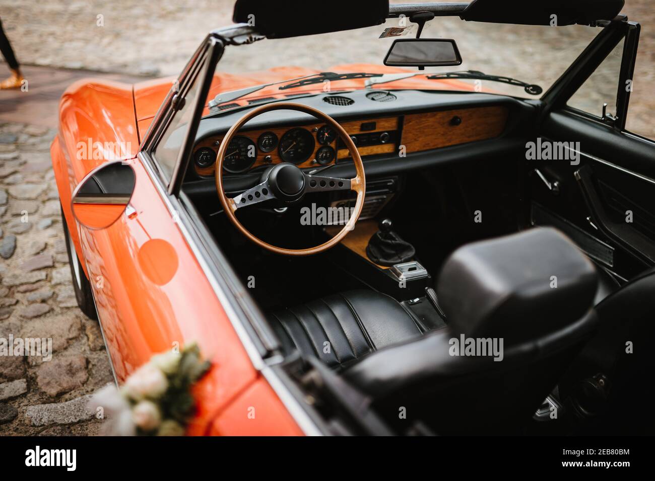 une voiture de mariage rouge avec des fleurs sur les poignées de porte Banque D'Images