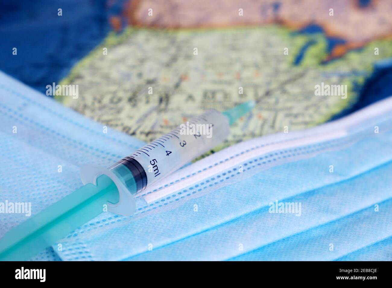 Vaccination aux États-Unis, seringues et masques médicaux sur la carte des États-Unis. Concept de soins de santé américains pendant la pandémie de Covid-19 Banque D'Images