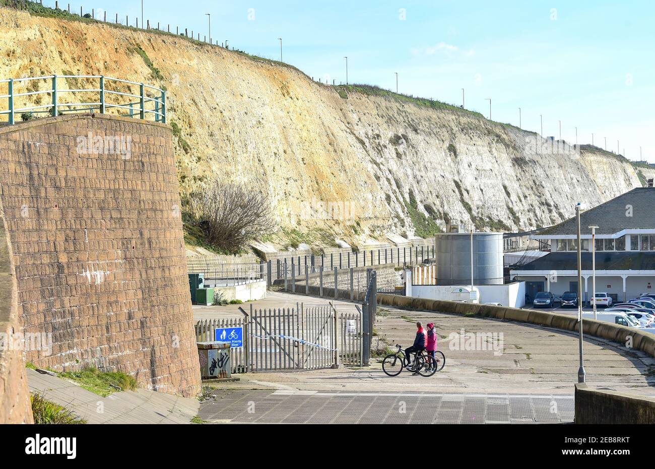 Brighton UK 12 février 2021 - les cyclistes vérifient la promenade sous la falaise par Brighton Marina a été fermée après que les passants ont été frappés récemment par des débris de craie et des rochers : Credit Simon Dack / Alamy Live News Banque D'Images