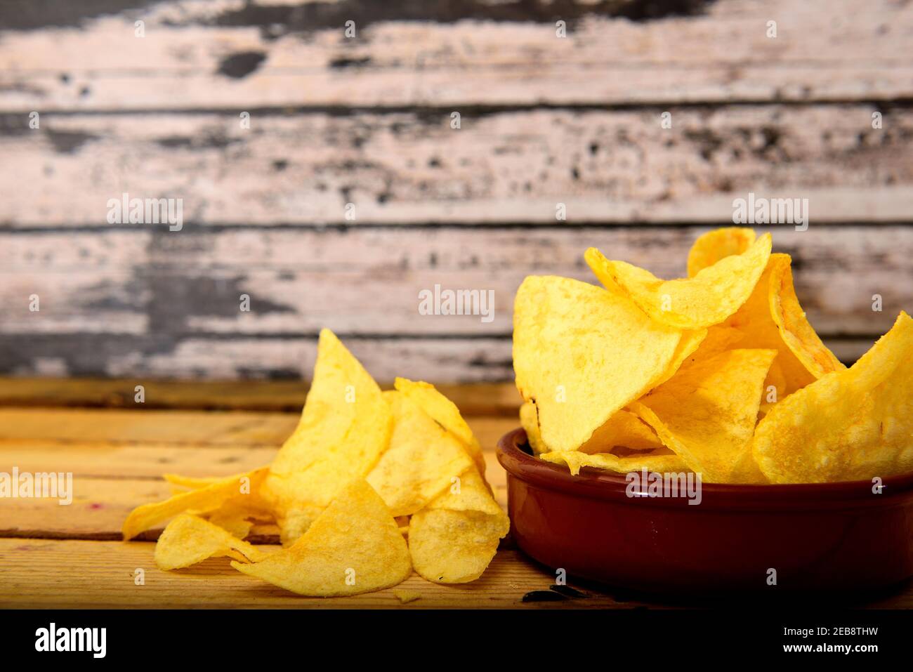 Chips faites maison dans une casserole en céramique sur une table en bois Banque D'Images