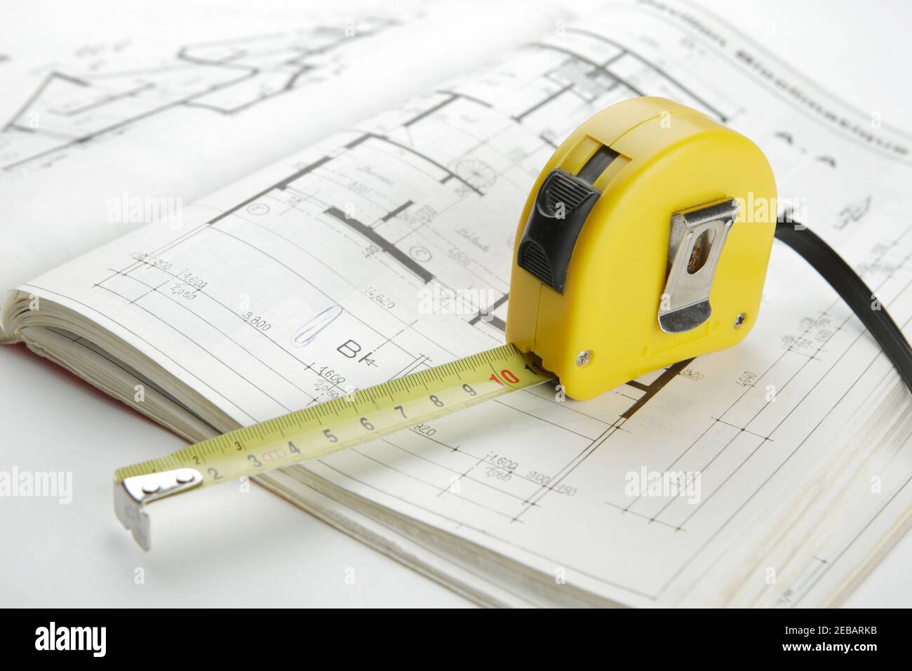 Concept d'archichecture avec ruban de mesure jaune sur un plan de construction Banque D'Images