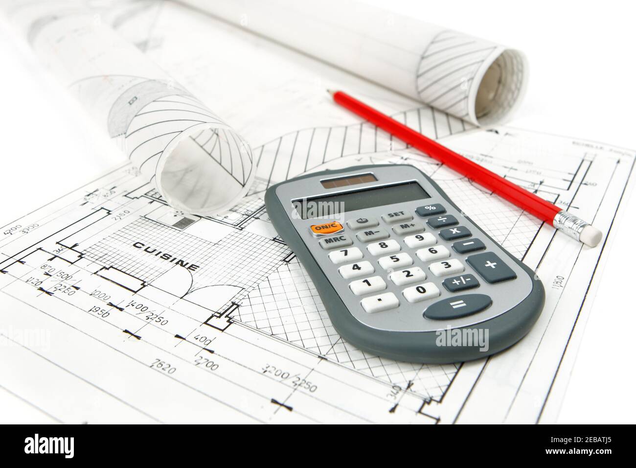 Gros plan de la calculatrice et du crayon placés sur les plans d'amélioration de la maison avec des rouleaux de dessins architecturaux. Prise de photos isolées sur fond blanc. Banque D'Images