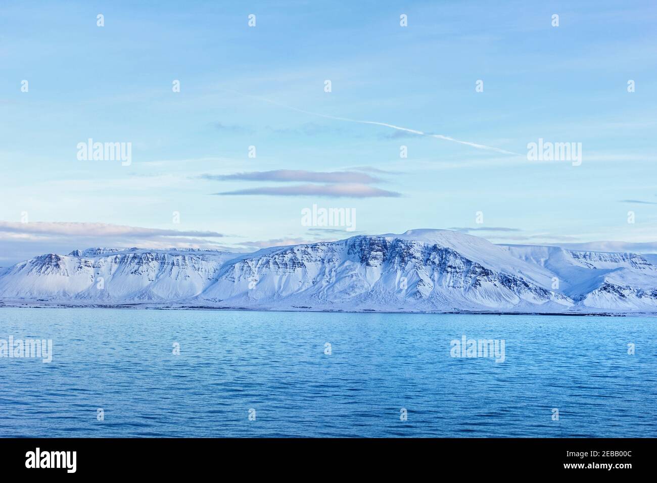 Les montagnes enneigées de l'Islande et l'eau de l'océan le jour d'hiver heureux Banque D'Images
