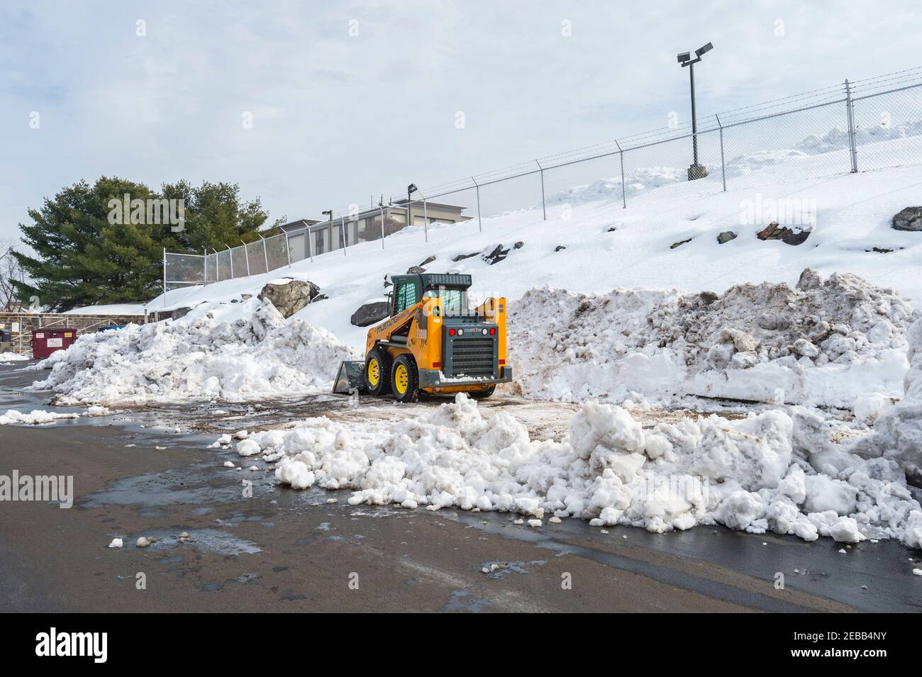 Petit chargeur frontal déblayant le terrain de stationnement de la neige après une grosse tempête de neige, Philadelphie, États-Unis Banque D'Images