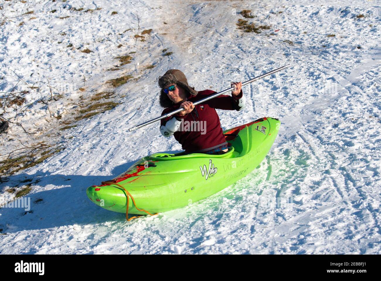 Édimbourg, Écosse, Royaume-Uni. 12 févr. 2021. Pendant que le temps froid continue, les membres du public sont à Holyrood Park jouant du sport et faisant des slogans politiques. Pic; UN homme dans un canot se lance sur une colline enneigée au pied du siège d’Arthur. Iain Masterton/Alamy Live News Banque D'Images