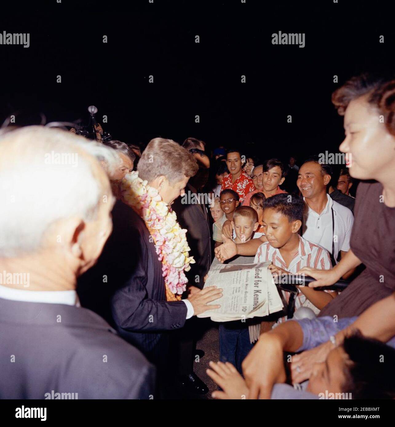 Voyage vers les États de l'Ouest : Honolulu, Hawaï, arrivée à l'aéroport international d'Honolulu, 9:10. Le président John F. Kennedy (au centre, portant la fleur leis) accueille les foules rassemblées à l'aéroport international d'Honolulu à Honolulu, Hawaï ; un jeune garçon tient une copie du journal Honolulu Star-Bulletin au président Kennedy, avec le titre, u0022Honolulu readied for Kennedy.u0022 Banque D'Images