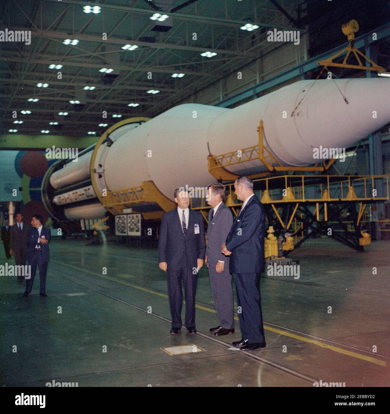 Visite d'inspection des installations de la NASA : Huntsville Alabama, Redstone Army Airfield et George C. Marshall Space Flight Centre, 9:35. Le président John F. Kennedy et le vice-président Lyndon B. Johnson visitent le directeur du George C. Marshall Space Flight Centre (MSFC), le Dr Wernher von Braun (au centre), lors d'une visite du MSFC à Redstone Arsenal, Huntsville, Alabama; l'agent du service secret de la Maison Blanche, Bill Duncan, marche à l'extrême gauche. La fusée C-1 de Saturn est en arrière-plan. Le président Kennedy a visité la MSFC dans le cadre d'une visite d'inspection de deux jours de l'Administration nationale de l'aéronautique et de l'espace Banque D'Images