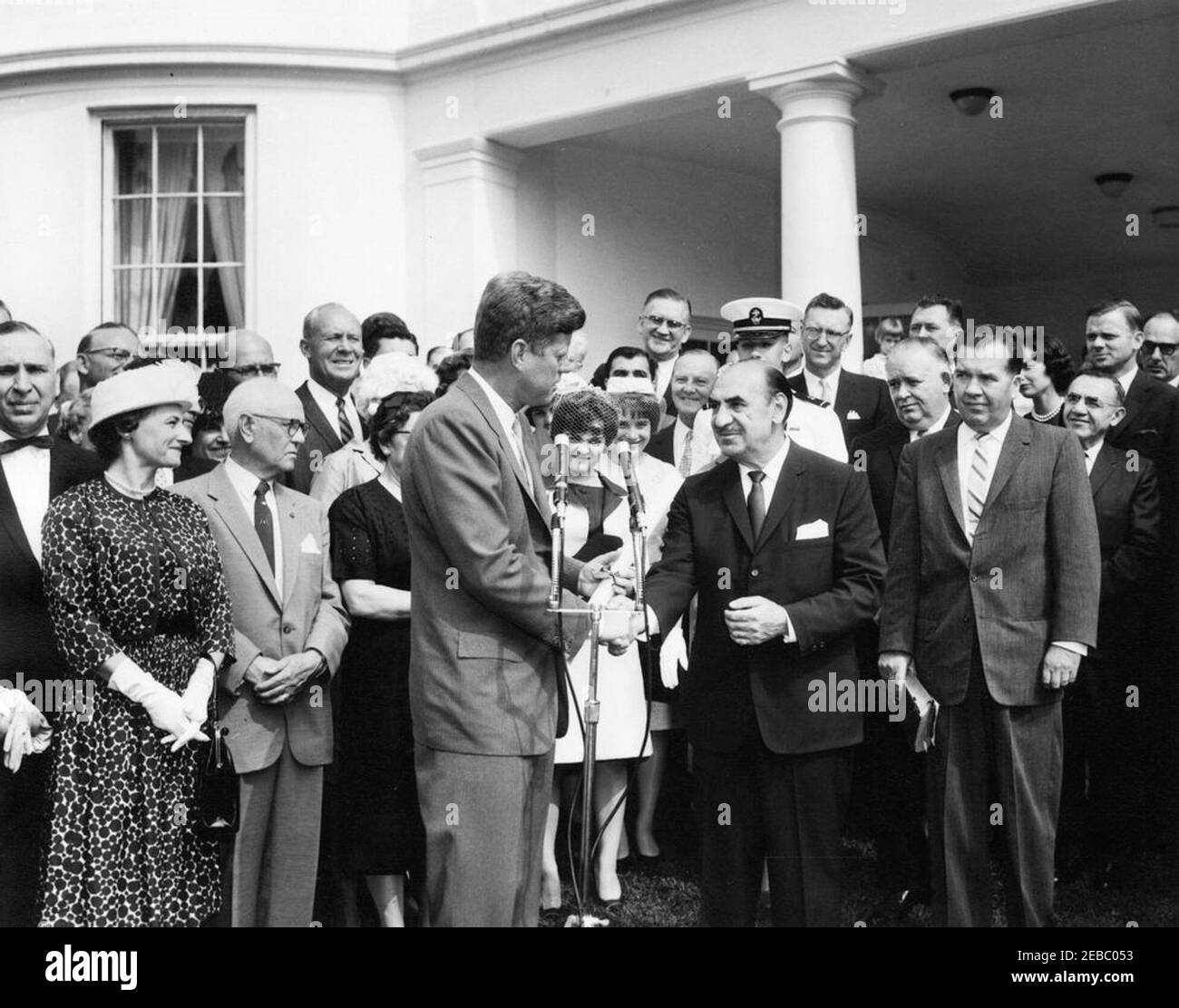 Cérémonie d'assermentation, secrétaire à la Santé, à l'éducation et au bien-être social (HEW) Anthony Celebrezze, 10 h 12. Le président John F. Kennedy tremble la main avec le secrétaire à la Santé, à l'éducation et au bien-être social, Anthony J. Celebrezze, lors de la cérémonie d'assermentation du secrétaire Celebrezzeu2019s. Aussi en photo : Susan Celebrezze; Jean Celebrezze; le sage de première classe Anthony J. Celebrezze, Jr.; Frank D. Celebrezze, Jr.; le sénateur Stephen M. Young (Ohio); le maire de Cleveland (Ohio), Ralph S. Locher; l'agent administratif de la Maison Blanche, Carson M. Howell. West Wing Lawn, Maison Blanche, Washington, D.C. [Veuillez consulter le président du présidentu2 Banque D'Images