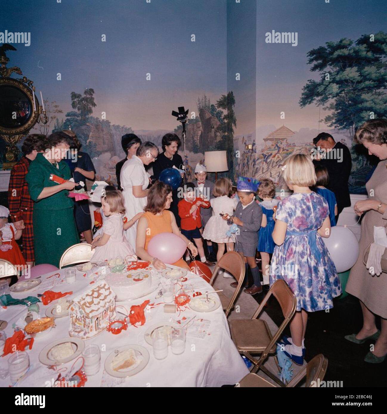 Fête d'anniversaire pour Caroline Kennedy et John F. Kennedy, Jr. La première dame Jacqueline Kennedy est assise à une table dans la salle à manger (résidence) du Presidentu2019s de la Maison Blanche, Washington, D.C., lors d'une fête d'anniversaire conjointe pour Caroline Kennedy et John F. Kennedy, Jr.; Caroline (au centre à droite, avec dos à la caméra) se tient en arrière-plan. Également en photo : Avery Hatcher, fils du secrétaire de presse associé, Andrew T. Hatcher; Shawn fragile, ami de la famille Kennedy; Maria Shriver; Janet Auchinclors; photographe de la Maison Blanche, le capitaine Cecil Stoughton. Banque D'Images