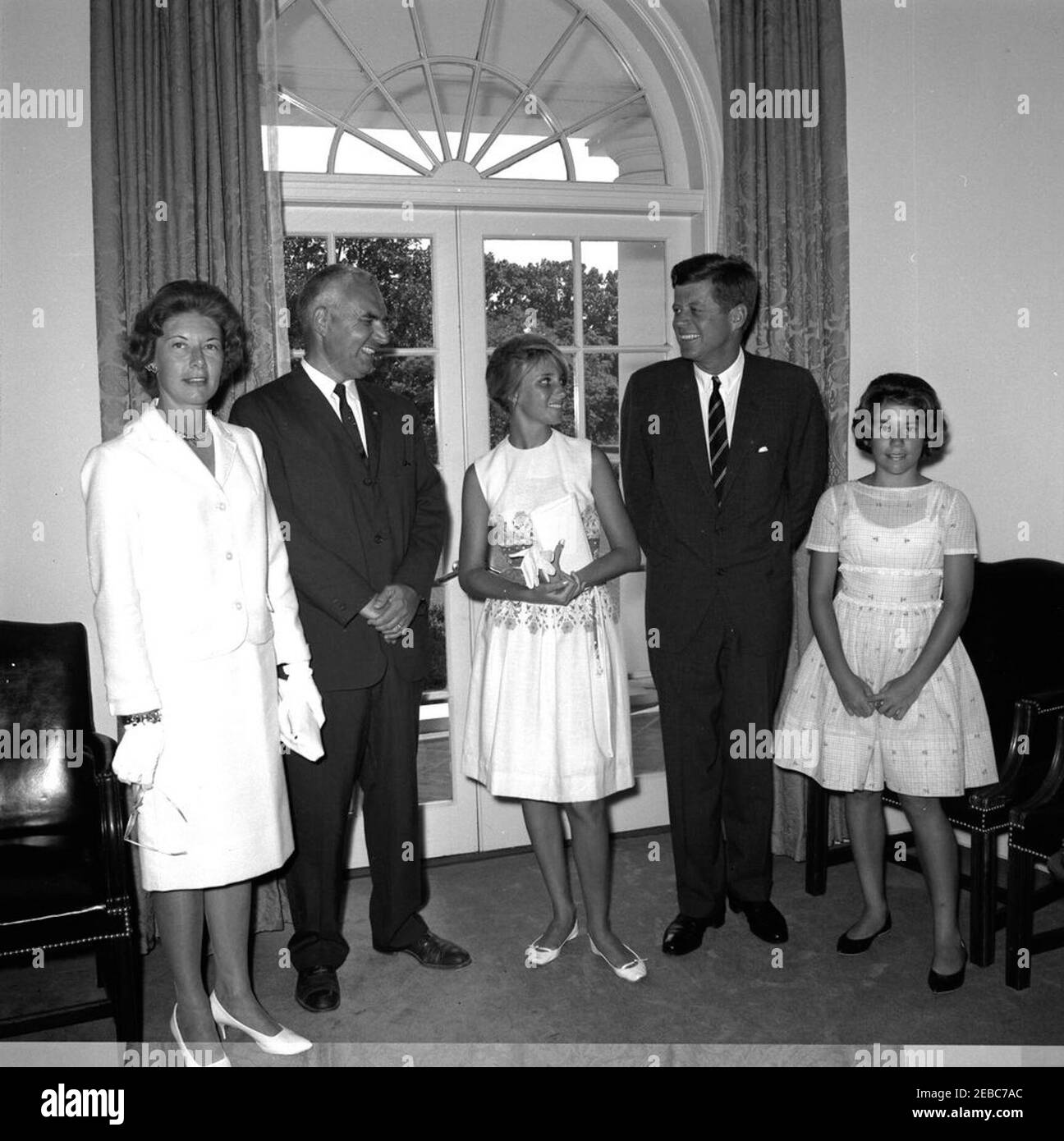 Visite de la famille Cushman de Northbrook, Illinois, en compagnie de Luisa Spadaccini, étudiante du Rotary International Exchange au Brésil. Le président John F. Kennedy visite la famille Cushman, de Northbrook, Illinois, et Luisa Spadaccini, étudiante en bourse Rotary International du Brésil. De gauche à droite : Dorothy Cushman; J. Kent Cushman; Mme Spadaccini, du Club Rotary de Rio de Janeiro; la présidente Kennedy; Susan Cushman. Cabinet Room, White House, Washington, D.C. [le bas du négatif contient un chevauchement d'une image inconnue.] Banque D'Images