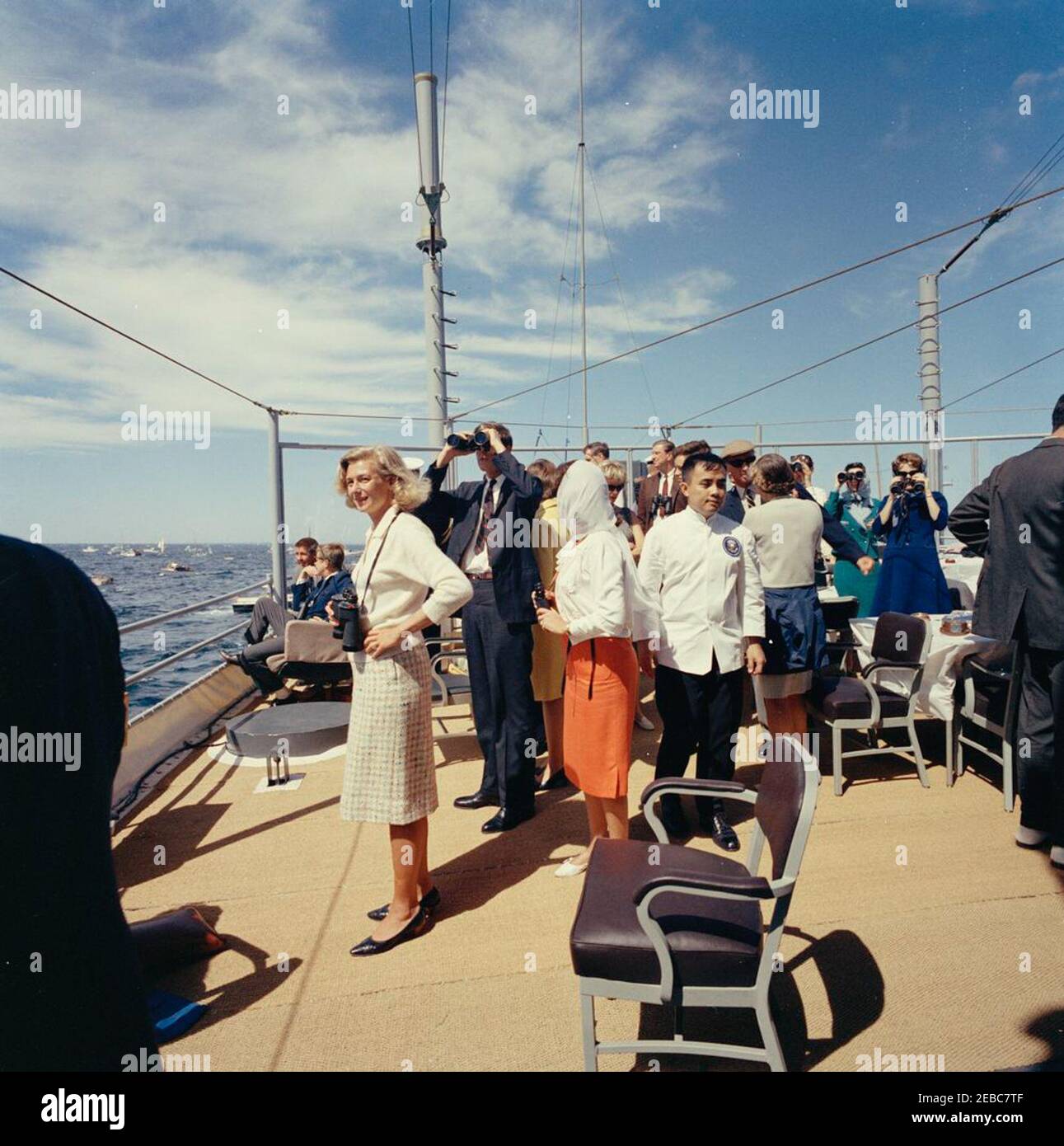 Le Président Kennedy Watches la 1ère course de la coupe Americau0027s. Le président John F. Kennedy (assis à gauche, en arrière-plan) regarde la première course de la coupe Americau0027s 1962 à bord de l'USS Joseph P. Kennedy, Jr. Également en photo : le sénateur Benjamin A. Smith II (Massachusetts); Nuala Pell, épouse du sénateur Claiborne Pell (Rhode Island); John Kerry Forbes; Franklin D. Roosevelt, Jr. Chef du protocole, Angier Biddle Duke. Newport, Rhode Island. Banque D'Images