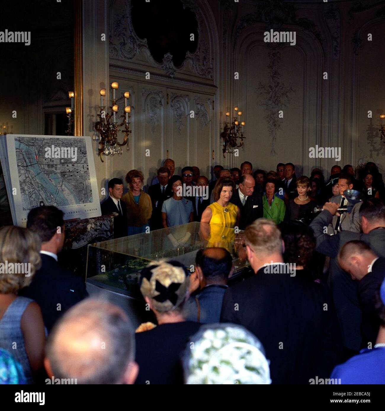 La première dame voit le modèle du Centre culturel national de Newport, Rhode Island. La première dame Jacqueline Kennedy (au centre, portant une robe jaune), voit un modèle architectural du Centre culturel national lors d'une cérémonie de dévoilement au manoir Elms de Newport, Rhode Island. Également en photo : actrice, Geraldine page; artiste du spectacle, Danny Kaye; présidente du Comité de campagne de la région de Washington pour le Centre culturel national, Janet Auchincloss; directrice musicale de l'Orchestre symphonique de Boston, Erich Leinsdorf; architecte, Edward Durell, Stone; membre du Comité consultatif des arts pour Banque D'Images