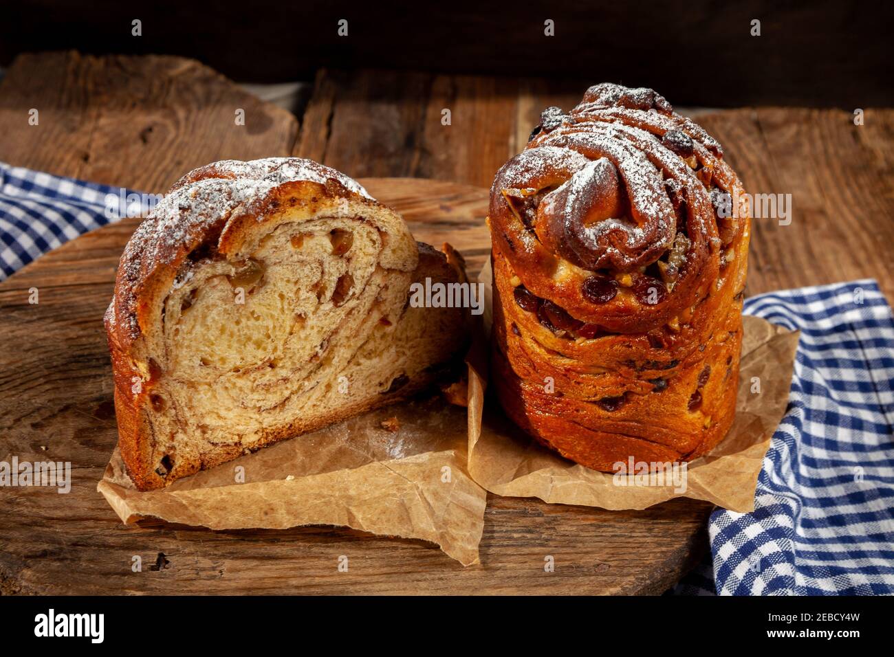 Kraffin gâteau de Pâques. Kraffins aux raisins secs, fruits confits et graines de pavot, arrosés de sucre en poudre. Gros plan de gâteau maison. Brut. Banque D'Images