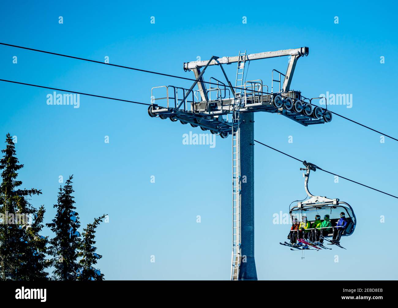 Groupe de skieurs qui font monter une remontée mécanique jusqu'au sommet d'une montagne dans une station de ski. Banque D'Images