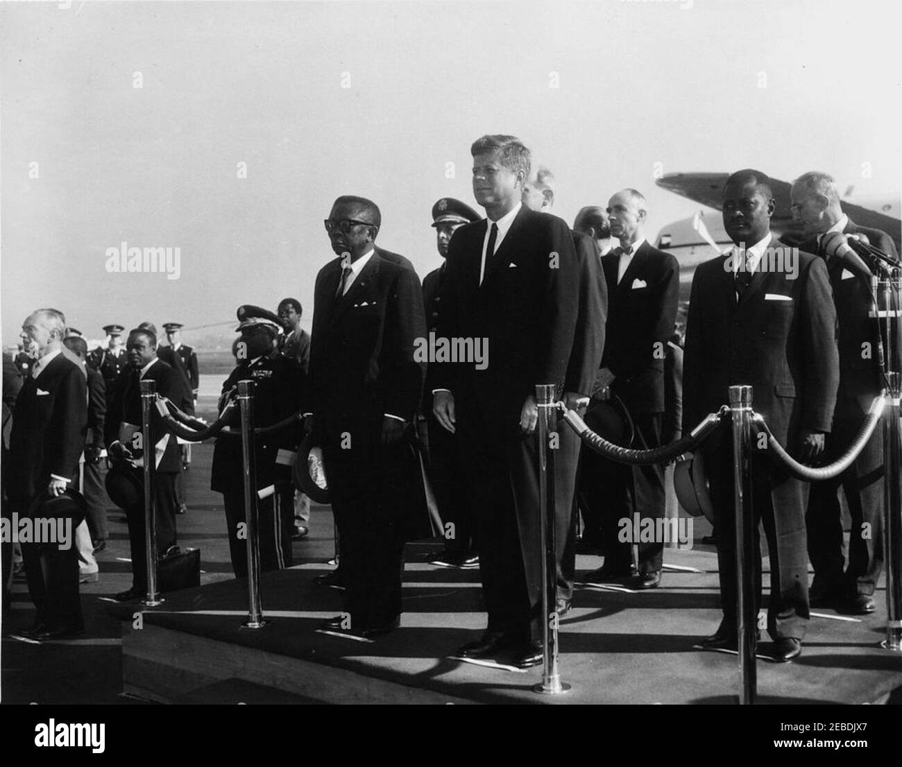 Cérémonies d'arrivée de William Vacanarat Shadrach Tubman, Président du Libéria, 10 h 00. Cérémonies d'arrivée pour William V.S. Tubman, Président du Libéria. Sur plate-forme, première rangée (L u2013 R): Président Tubman; président John F. Kennedy. Deuxième rangée: Homme non identifié (caché); Secrétaire d'État Dean Rusk (pour la plupart caché); S. Edward Peal, Ambassadeur du Libéria. Troisième rangée: Chef d'état-major interarmées, le général Lyman Lemnitzer; Elbert G. Mathews, ambassadeur au Libéria; homme non identifié. Quatrième rangée: Chef du protocole Angier Biddle Duke (face à l'extérieur de la caméra). Autres non identifiés. Andrews Air Banque D'Images