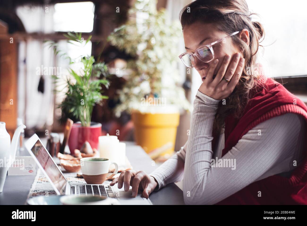 femme professionnelle dans les types de lunettes sur l'ordinateur dans le bureau à domicile avec thé Banque D'Images