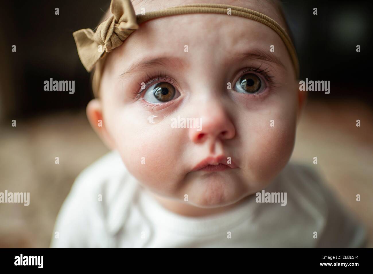 Gros plan de bébé fille triste avec des lèvres pouting et gros yeux tentants Banque D'Images